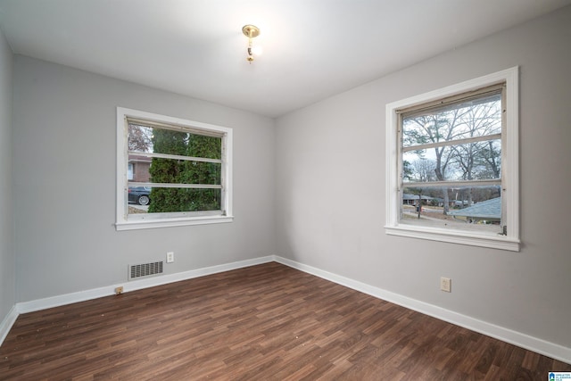 unfurnished room featuring visible vents, baseboards, and wood finished floors