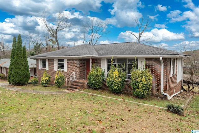 ranch-style house featuring brick siding, a front lawn, and a shingled roof