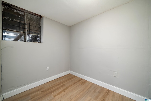 unfurnished room with baseboards and wood finished floors