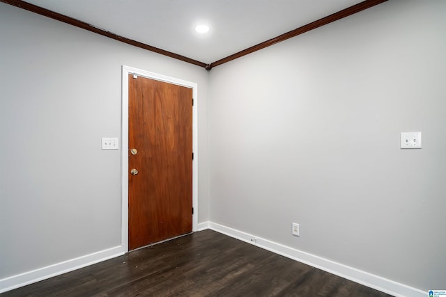 spare room with dark wood-style floors, ornamental molding, and baseboards