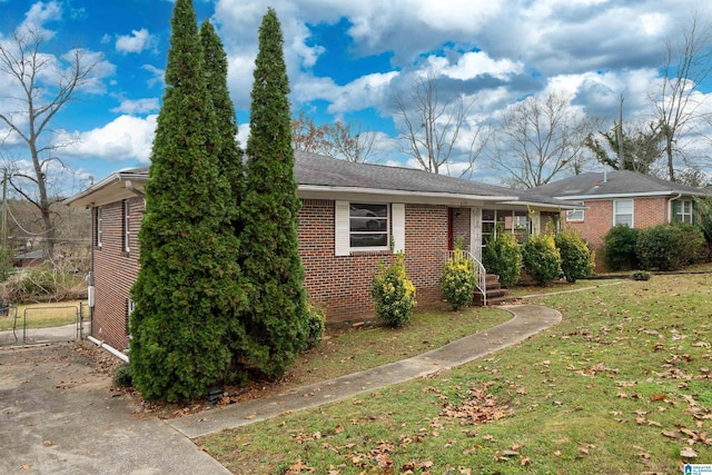 ranch-style house featuring a gate, a front lawn, and brick siding