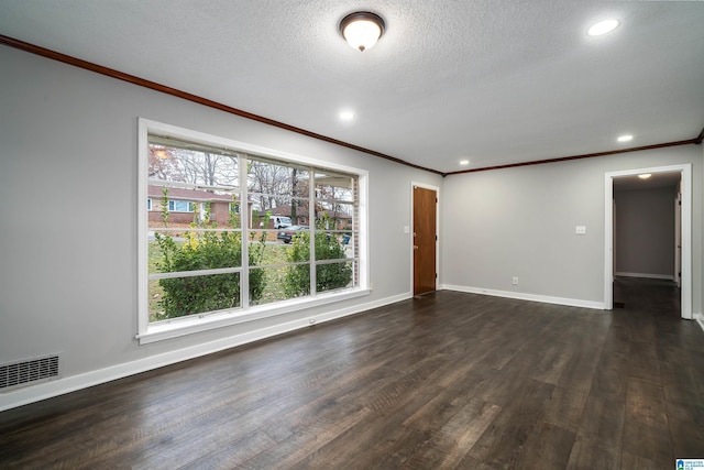 empty room with dark wood-type flooring, visible vents, a textured ceiling, and baseboards