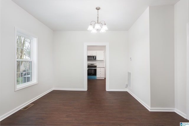 unfurnished dining area with a notable chandelier and dark hardwood / wood-style floors