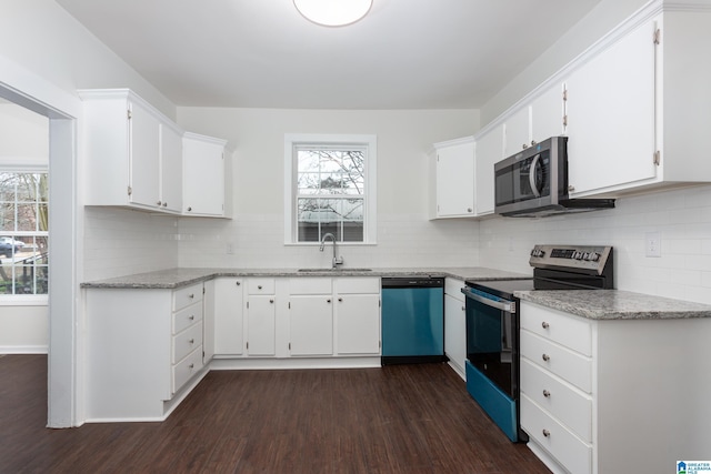 kitchen with white cabinets, sink, dark hardwood / wood-style floors, decorative backsplash, and stainless steel appliances