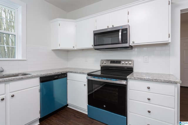 kitchen featuring light stone countertops, appliances with stainless steel finishes, dark hardwood / wood-style floors, and white cabinetry