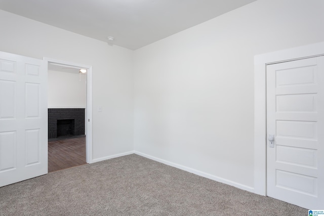 carpeted empty room featuring a fireplace