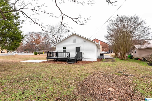 back of property featuring a lawn and a wooden deck