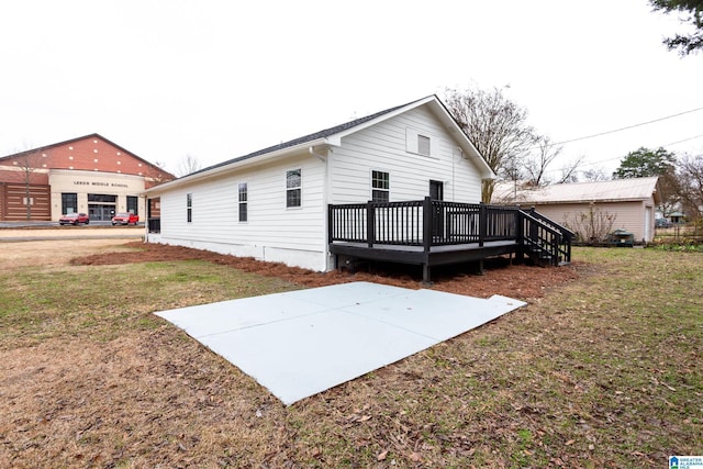 rear view of property featuring a wooden deck and a yard