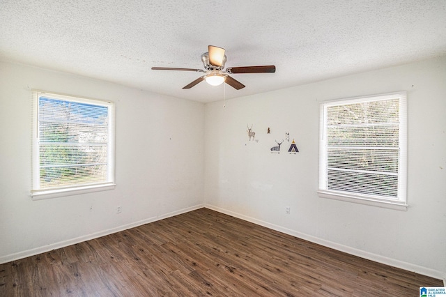 empty room with ceiling fan, dark wood-type flooring, and a textured ceiling