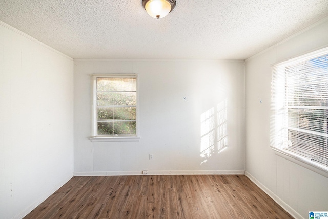 unfurnished room featuring a textured ceiling, crown molding, and dark hardwood / wood-style floors