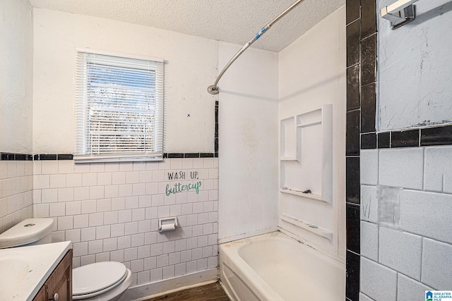 full bathroom with vanity, toilet, a textured ceiling, tile walls, and tub / shower combination