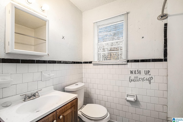 bathroom featuring vanity, a textured ceiling, toilet, and tile walls