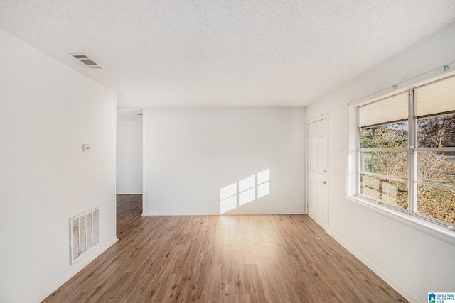 empty room featuring a textured ceiling and hardwood / wood-style flooring