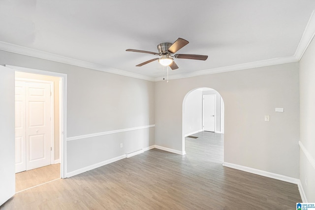 empty room featuring ceiling fan, hardwood / wood-style floors, and ornamental molding