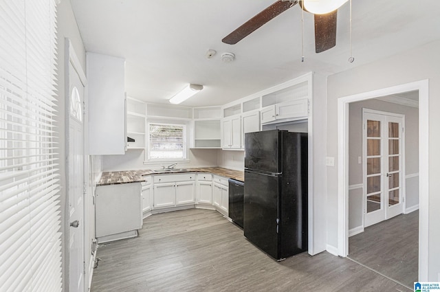 kitchen featuring black appliances, white cabinets, light wood-type flooring, and sink