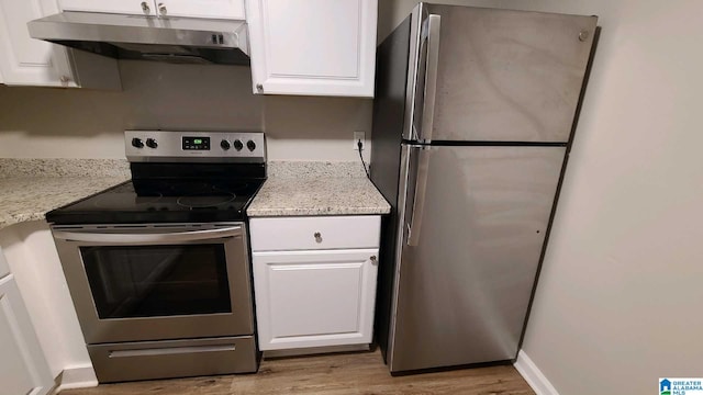 kitchen featuring white cabinets, stainless steel appliances, and light stone countertops