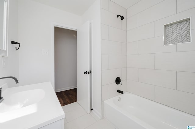 bathroom with tile patterned floors, vanity, and tiled shower / bath