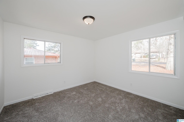 spare room featuring dark colored carpet