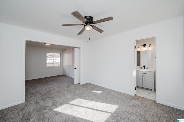 unfurnished bedroom featuring light colored carpet, ensuite bath, and ceiling fan