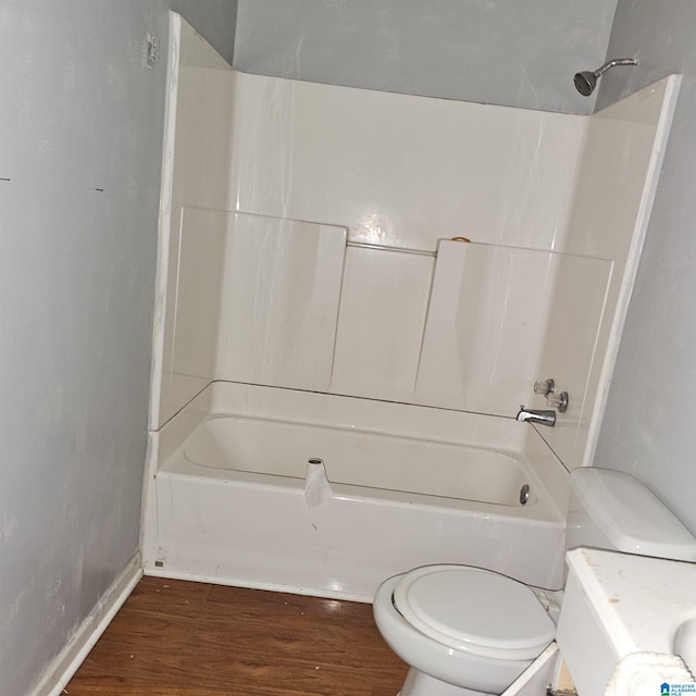 bathroom featuring bathing tub / shower combination, wood-type flooring, and toilet