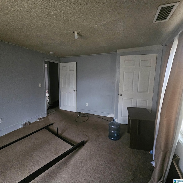 unfurnished bedroom with carpet flooring and a textured ceiling