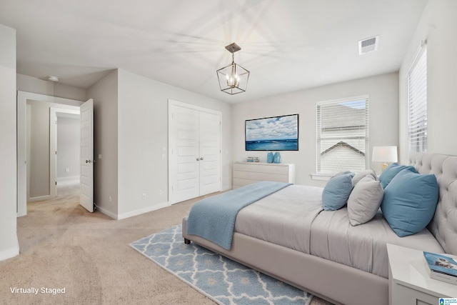 carpeted bedroom with an inviting chandelier and a closet