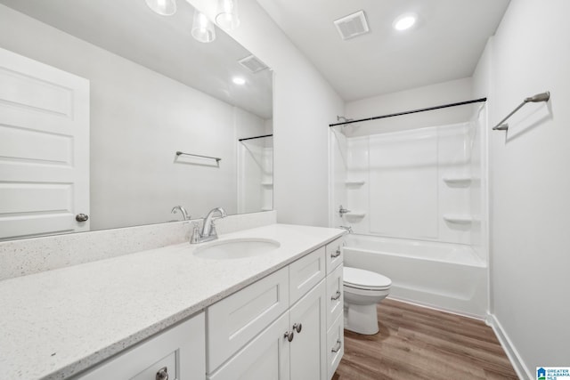 full bathroom featuring hardwood / wood-style floors, vanity, toilet, and shower / washtub combination