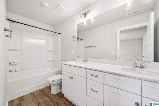 full bathroom with hardwood / wood-style floors, vanity, bathing tub / shower combination, and toilet