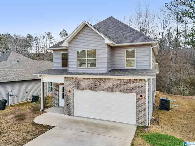 view of front property featuring a garage and central AC