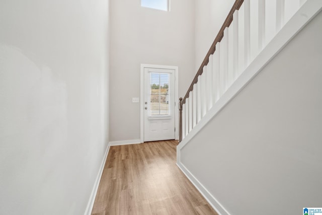 entryway with a towering ceiling and light hardwood / wood-style floors