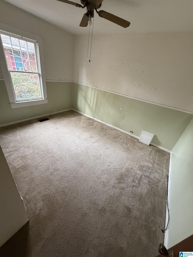 unfurnished room featuring ceiling fan and carpet