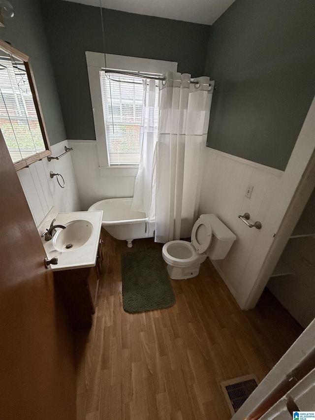 bathroom featuring plenty of natural light, vanity, hardwood / wood-style floors, and toilet