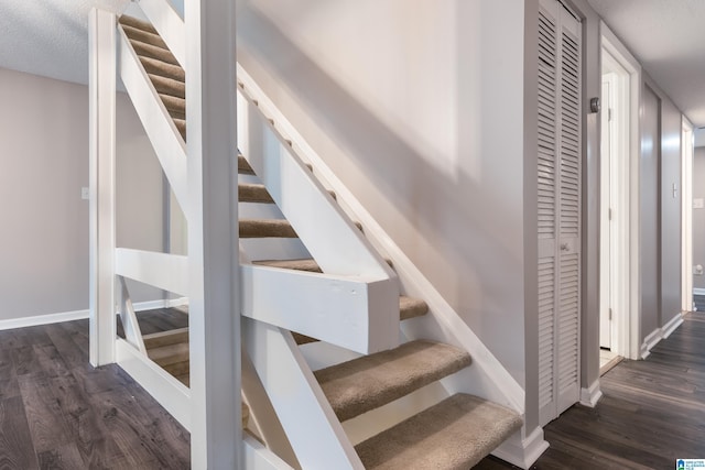 staircase featuring wood-type flooring and a textured ceiling