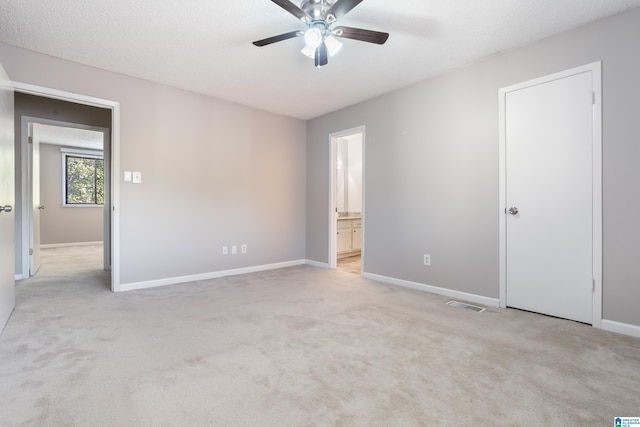 unfurnished room with a textured ceiling, light colored carpet, and ceiling fan