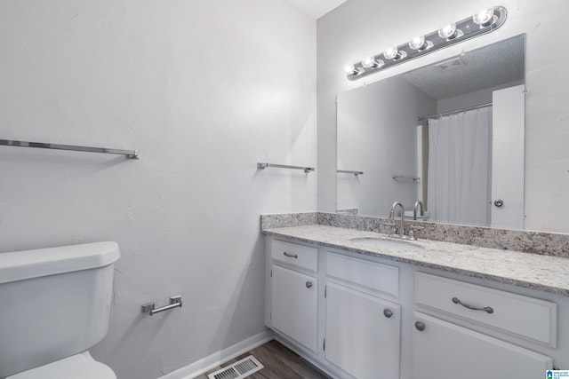 bathroom with hardwood / wood-style floors, vanity, and toilet