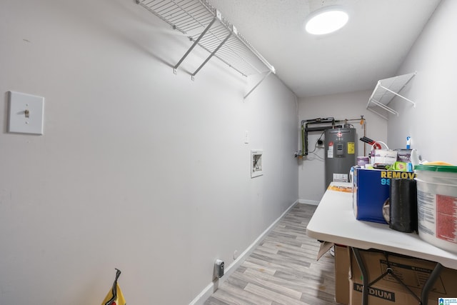 clothes washing area featuring washer hookup, electric water heater, and light hardwood / wood-style floors