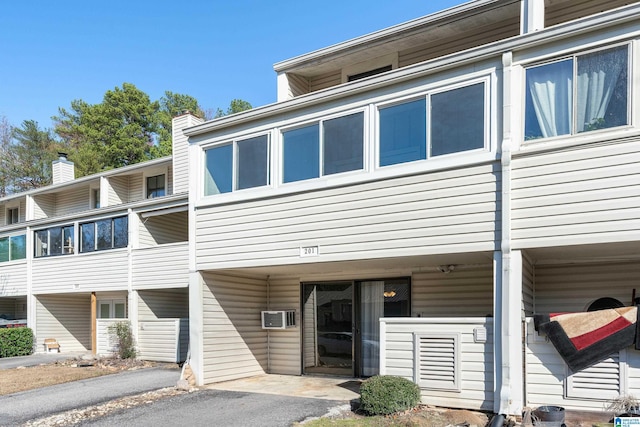 view of front of house with a wall mounted AC