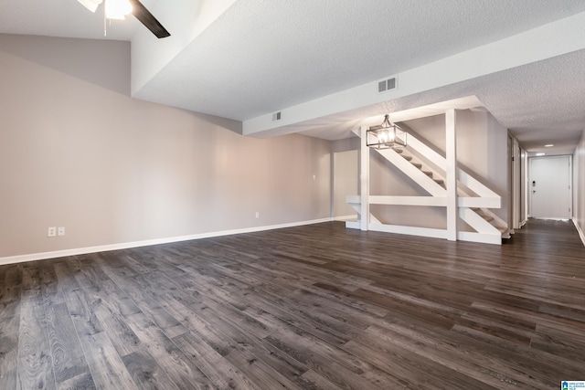 basement with a textured ceiling, dark hardwood / wood-style floors, and ceiling fan