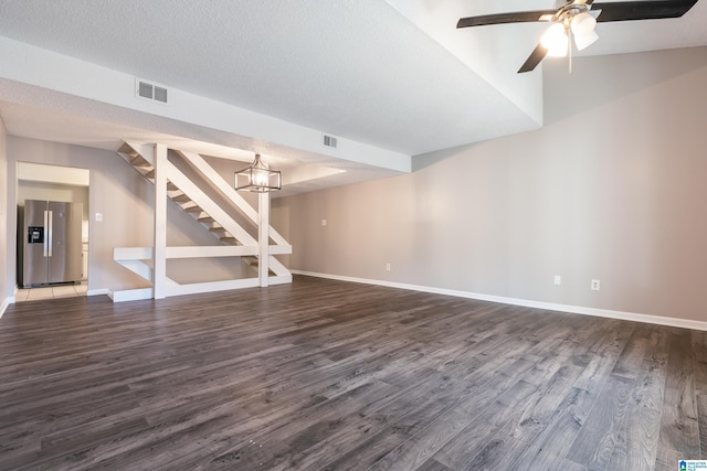 unfurnished living room featuring a textured ceiling, ceiling fan with notable chandelier, and dark wood-type flooring