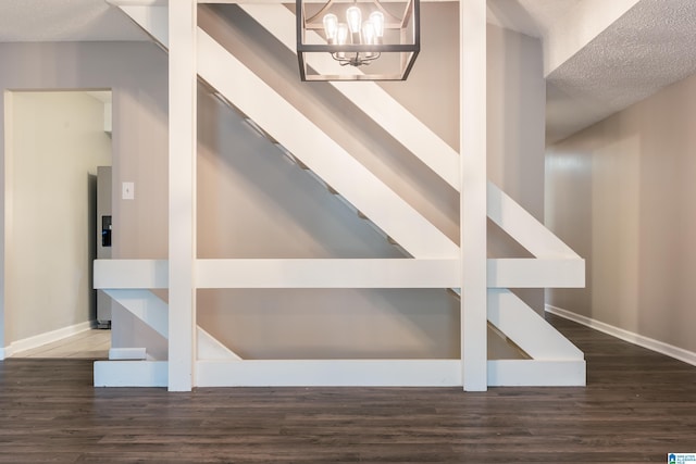 interior space with a textured ceiling, an inviting chandelier, and dark wood-type flooring