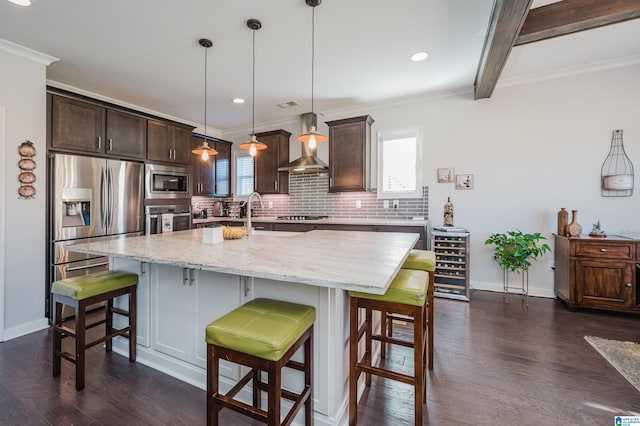 kitchen featuring stainless steel appliances, a center island with sink, hanging light fixtures, and dark wood-type flooring