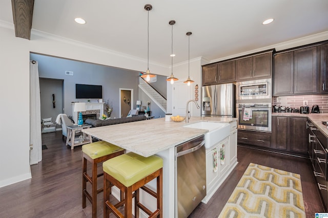 kitchen with pendant lighting, a kitchen breakfast bar, dark hardwood / wood-style flooring, dark brown cabinetry, and stainless steel appliances