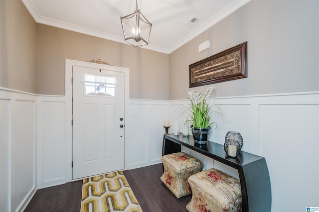 foyer entrance with ornamental molding and dark wood-type flooring