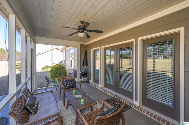 sunroom / solarium featuring plenty of natural light, ceiling fan, and wood ceiling