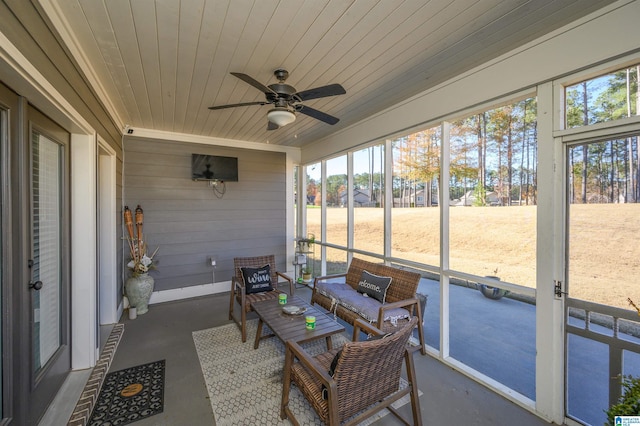 sunroom featuring ceiling fan, wooden ceiling, and a wealth of natural light