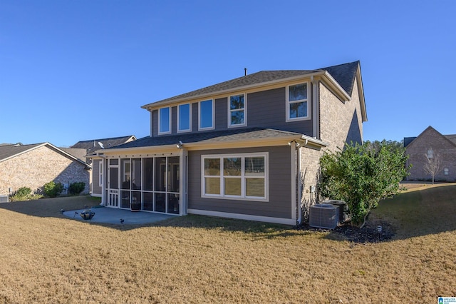 rear view of property with a yard, central AC unit, and a sunroom