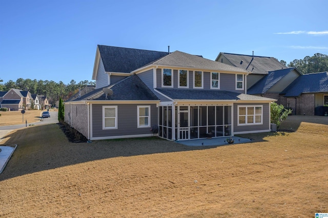 back of property featuring a sunroom and a yard