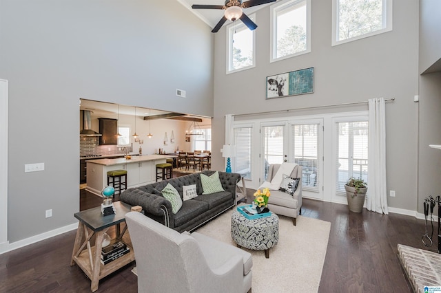 living room featuring ceiling fan, french doors, a towering ceiling, and dark hardwood / wood-style floors