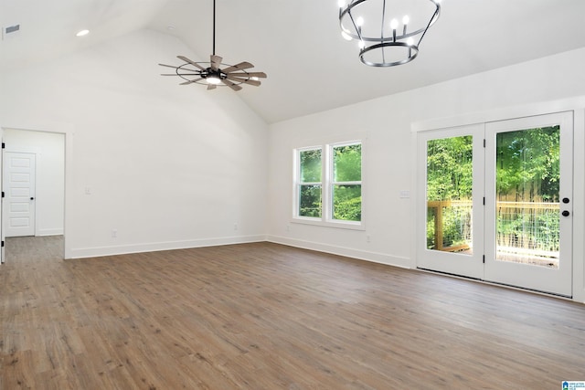 interior space with high vaulted ceiling, wood-type flooring, and ceiling fan with notable chandelier