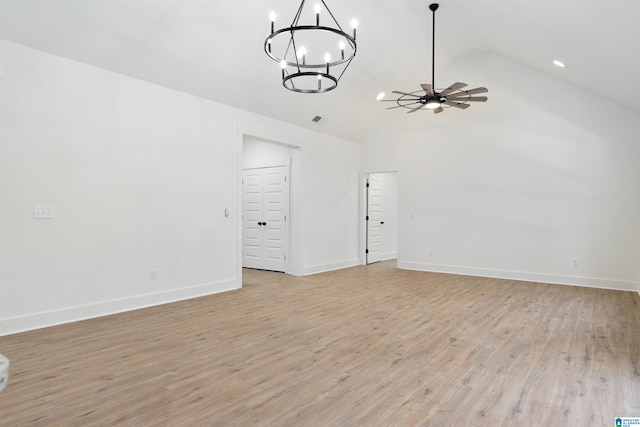 unfurnished living room with lofted ceiling, ceiling fan with notable chandelier, and light hardwood / wood-style flooring